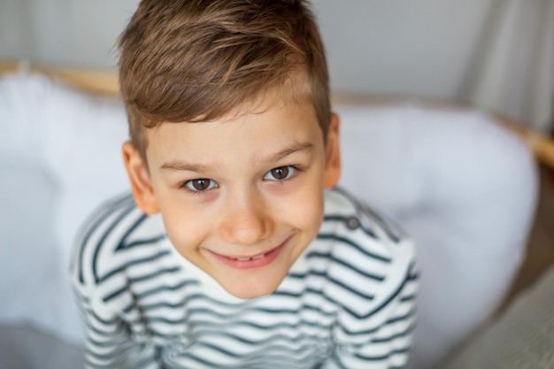 Retrato de ángulo alto de un niño sonriente sentado en casa