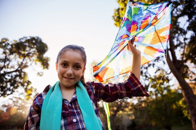 Retrato de ángulo bajo de niña con cometa