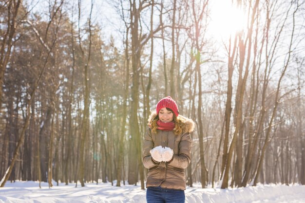 Retrato ao ar livre da garota do Natal. Mulher de inverno soprando de neve em um parque.