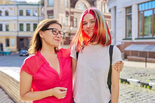 Retrato ao ar livre de feliz mãe e filha de adolescente 16, 17 anos abraçando juntos. Família, estilo de vida, dia das mães