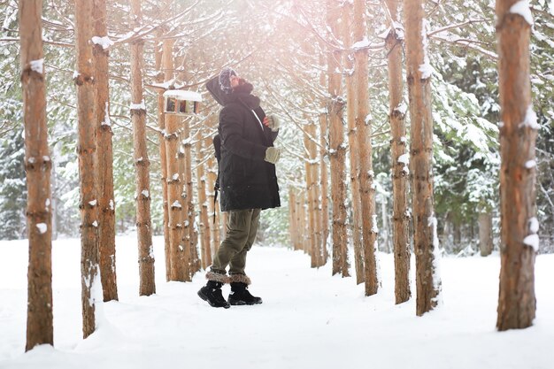 Retrato ao ar livre de homem bonito com casaco e casco. homem barbudo na floresta de inverno.