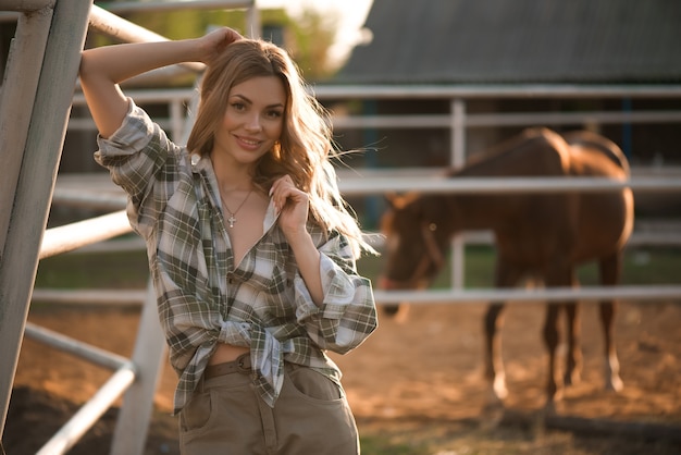 Retrato ao ar livre de jovem e bela mulher sexual com cavalo