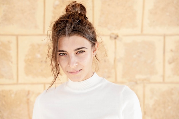 Retrato ao ar livre de jovem vestido de branco posando na rua