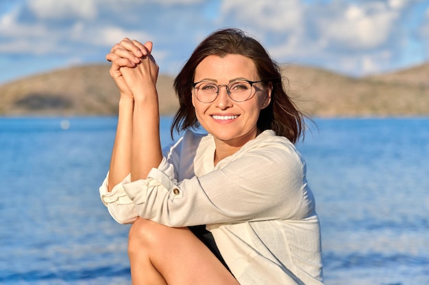 Retrato ao ar livre de uma bela mulher sorridente de meia idade olhando para a câmera