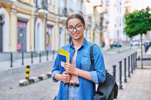 Retrato ao ar livre de uma estudante adolescente sorridente olhando para a câmera na cidade