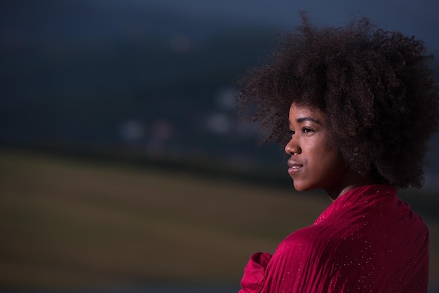 Retrato ao ar livre de uma jovem e bela mulher negra com lenço vermelho no ombro