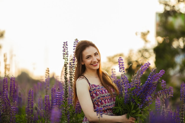 Retrato ao ar livre de uma morena linda jovem idade. garota sexy atraente em um campo com flores