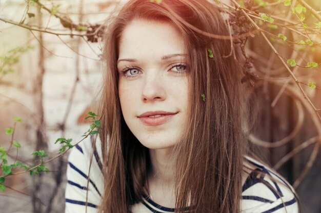 Retrato ao ar livre de uma mulher bonita com cabelo castanho e maquiagem naturalmente. destaque vermelho