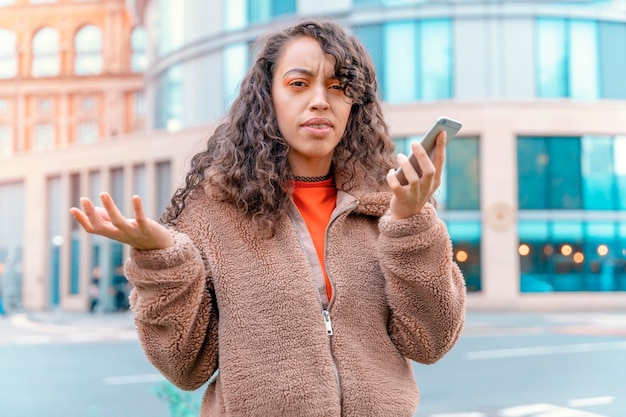 Retrato ao ar livre de uma mulher chateada usando um telefone celular visitando uma cidade da Europa
