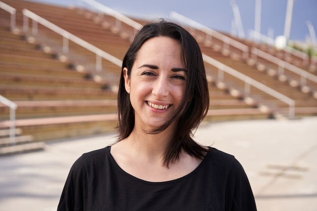 retrato ao ar livre de uma mulher latina com plano de fundo do estádio