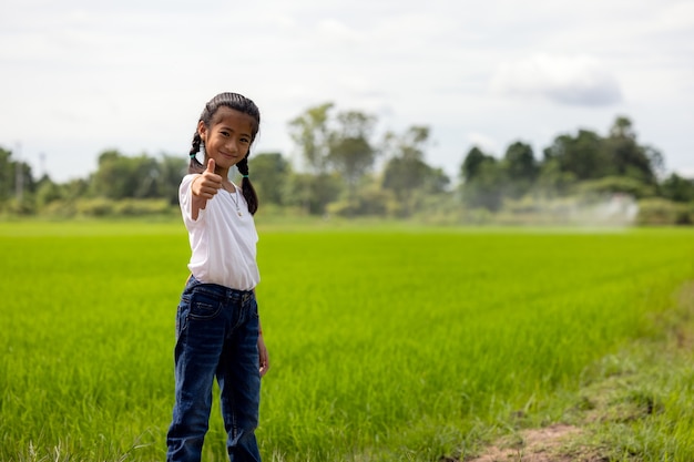 Retrato ao ar livre de uma pequena agricultora em campos de arroz