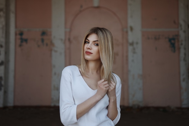 Retrato ao ar livre, estilo de vida, de uma bela jovem loira. posando em meio urbano. foto de moda