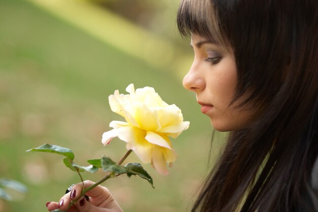 Retrato ao ar livre muito jovem com flor rosa amarela