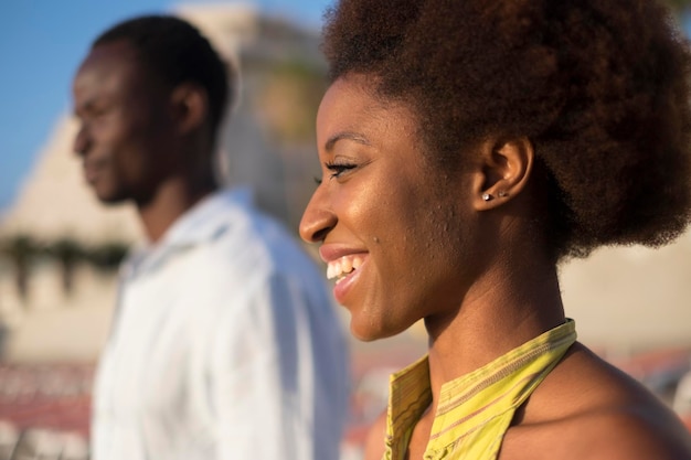 Retrato aproximado de dois jovens africanos de raça negra e mulher sorrindo para o sol em liberdade atividade de lazer ao ar livre juntos lindo casal afro aproveitando o horário de verão