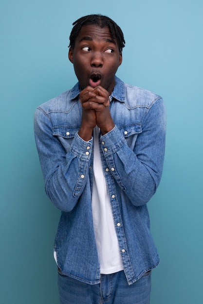 Retrato aproximado de um jovem africano surpreso com dreadlocks em uma jaqueta jeans