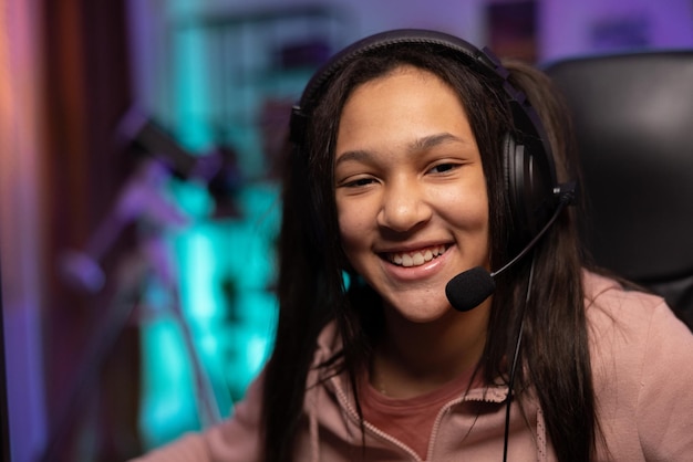 Retrato aproximado de um jovem jogador sorridente, a garota está feliz em ganhar o jogo, passar o nível da adolescente