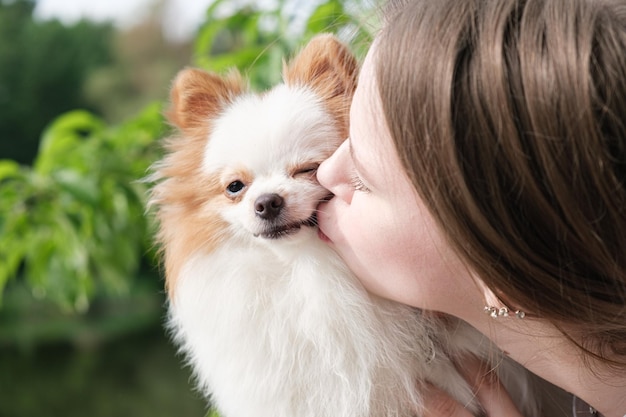 Retrato aproximado de um Pomeranian e uma jovem mulher