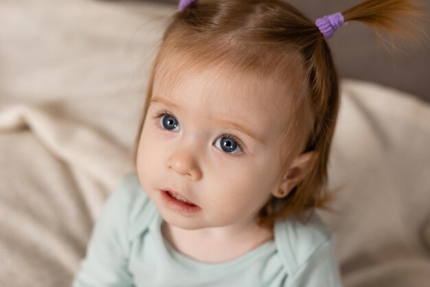 Retrato aproximado de uma garotinha encantadora com um penteado engraçado Foto de alta qualidade