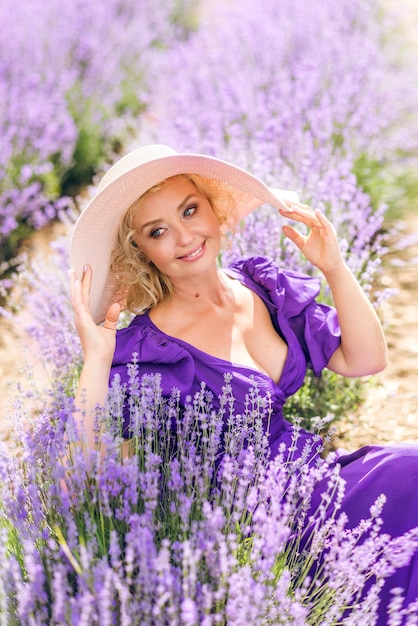 Retrato aproximado de uma idosa de chapéu Uma mulher está sentada em um campo de lavanda