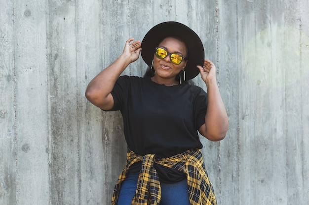 Retrato aproximado de uma jovem afro-americana estilosa com cabelo encaracolado em óculos de sol da moda em