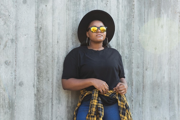 Retrato aproximado de uma jovem afro-americana estilosa com cabelo encaracolado em óculos de sol da moda em