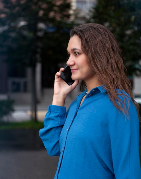 Retrato aproximado de uma jovem falando ao telefone na cidade