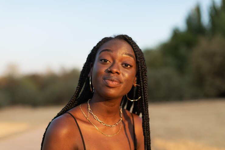 Foto retrato aproximado de uma jovem negra olhando expressivamente para a câmera no parque