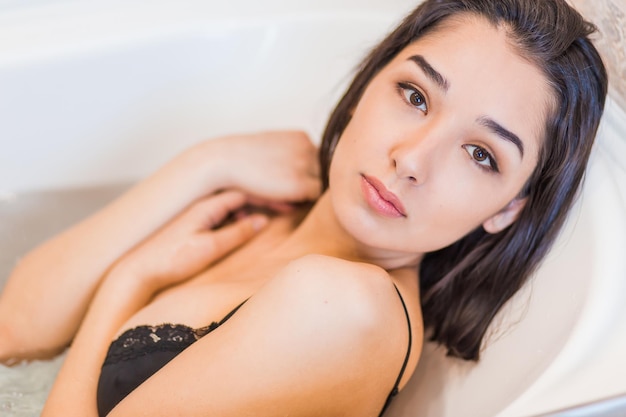 Retrato aproximado de uma jovem relaxando na banheira
