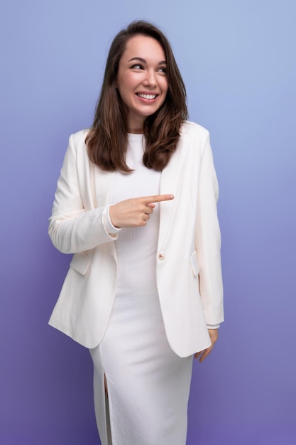 Retrato aproximado de uma morena europeia sorridente com cabelo comprido em um vestido branco e jaqueta