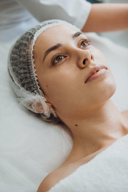 Foto retrato aproximado de uma mulher durante a massagem facial no salão spa tratamento facial beleza cuidados com a pele bea