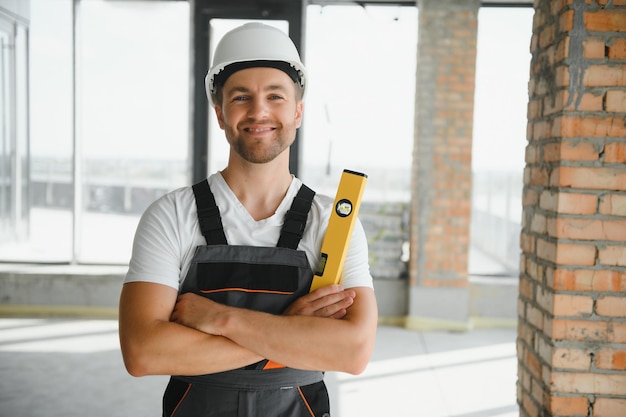 Retrato de un apuesto constructor masculino con un mono y un casco