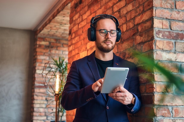 Retrato de un apuesto hombre barbudo con elegante traje listeni