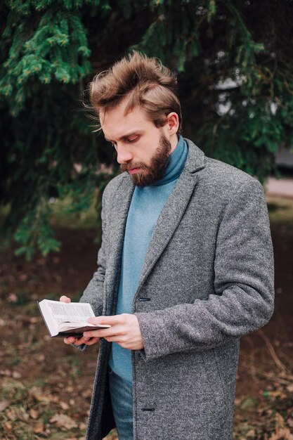 Retrato apuesto hombre barbudo leyendo un libro y relajándose Fondo borroso Efecto de película horizontal