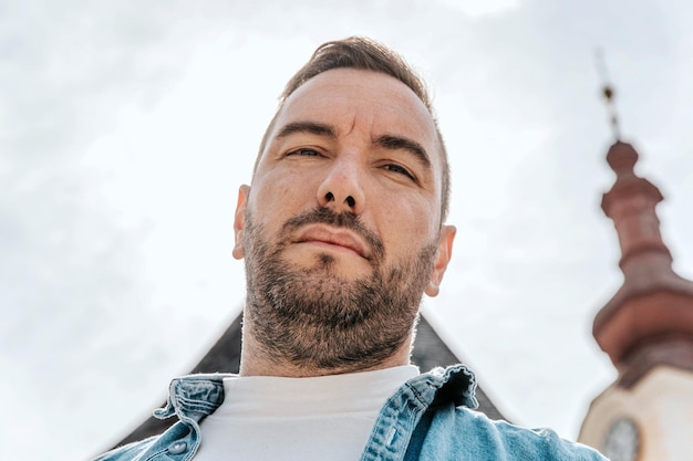 Retrato de un apuesto hombre hipster con una chaqueta de jean en una gran ciudad en la calle un concepto de estilo de vida