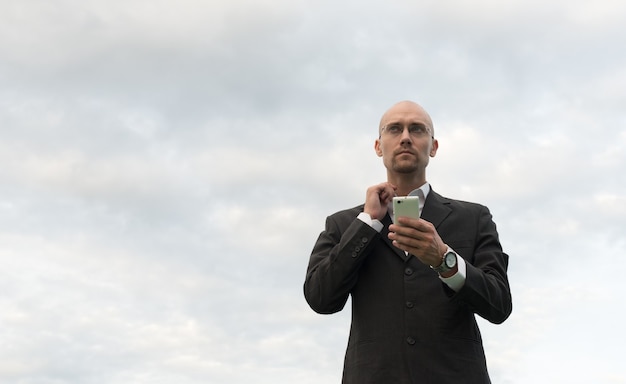 Retrato de apuesto hombre de negocios Calvo con rastrojo de barba contra la vista del cielo al aire libre