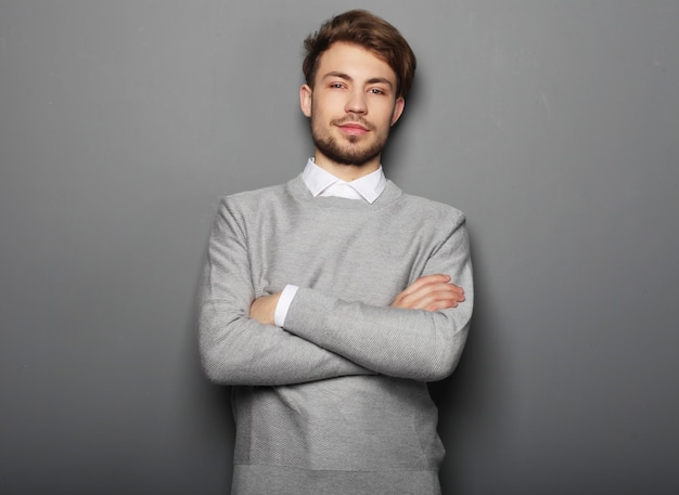 Retrato de un apuesto hombre de negocios confiado sobre espacio gris con espacio de copia