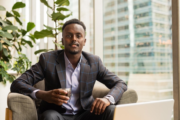 Retrato de un apuesto hombre de negocios negro bebiendo café