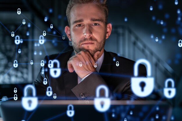 Retrato de un apuesto hombre de negocios que piensa cómo proteger la información confidencial de los clientes y la seguridad cibernética Iconos de candado de holograma de TI sobre el fondo de la oficina Mano en la barbilla