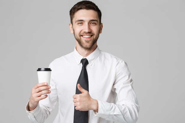 Retrato de un apuesto hombre de negocios en traje formal con una taza de café.