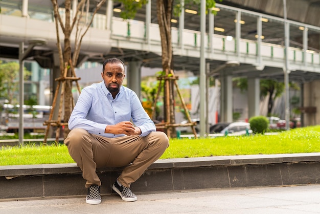 Retrato de un apuesto hombre negro en la ciudad listo para los negocios