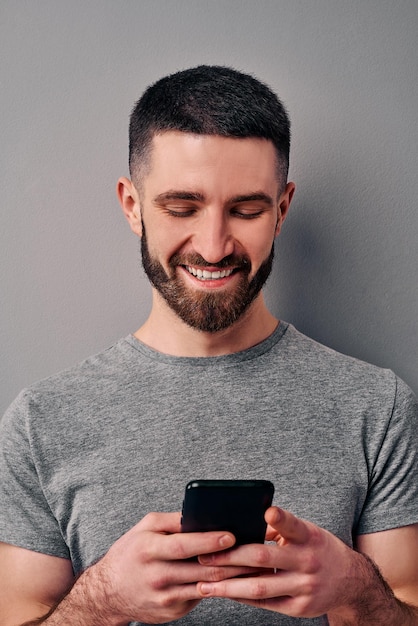 retrato apuesto hombre sosteniendo teléfono inteligente sonriendo vida en línea tecnología redes sociales blogs