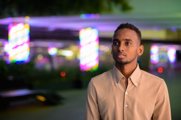 Retrato de apuesto joven empresario africano negro vistiendo ropa casual al aire libre en la ciudad