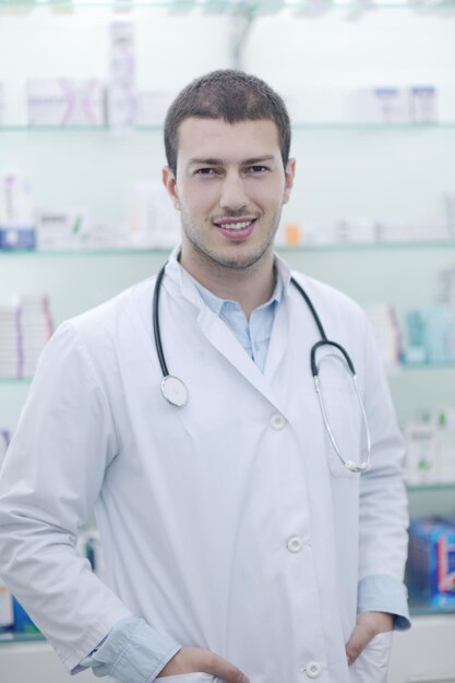 retrato de un apuesto joven farmacéutico químico de pie en la farmacia farmacia