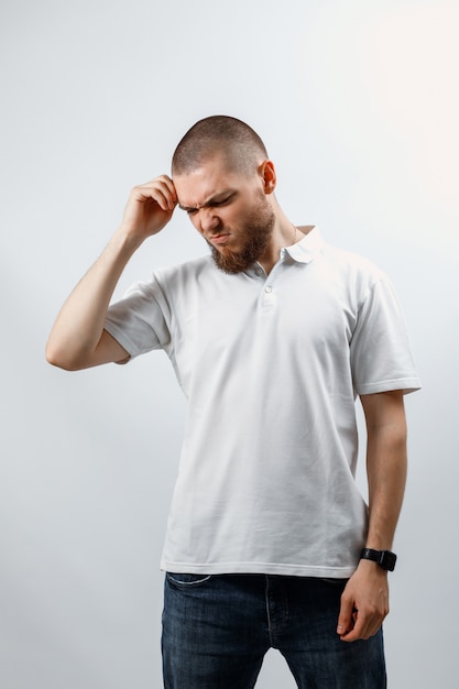 Retrato de un apuesto joven mirando hacia abajo en blanco