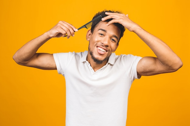 Retrato de apuesto joven negro afroamericano peinándose en el baño.