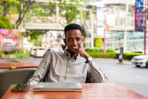 Retrato de un apuesto joven negro al aire libre en la ciudad