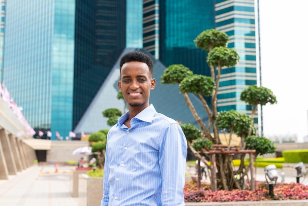 Retrato de un apuesto joven negro al aire libre en la ciudad