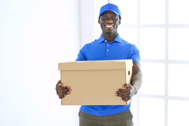 Retrato de un apuesto libertador feliz con caja