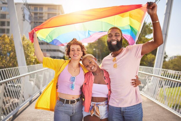 Foto retrato del arco iris y la bandera con amigos lgbt al aire libre juntos por la diversidad, el orgullo gay o la libertad. apoyar la igualdad y los derechos humanos con un grupo de amigos de hombres y mujeres que se encuentran afuera por la política.