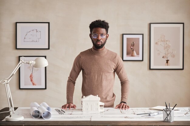 Retrato de un arquitecto confiado en la oficina con un interior minimalista